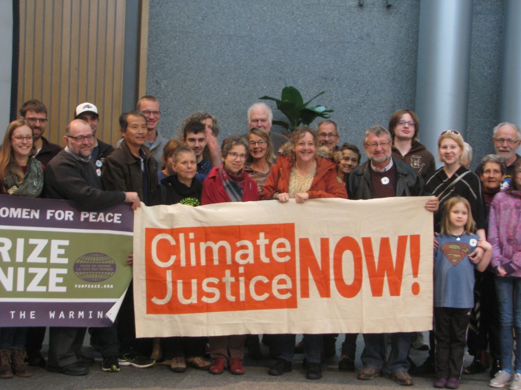 People holding a banner "Climate Justice Now!"