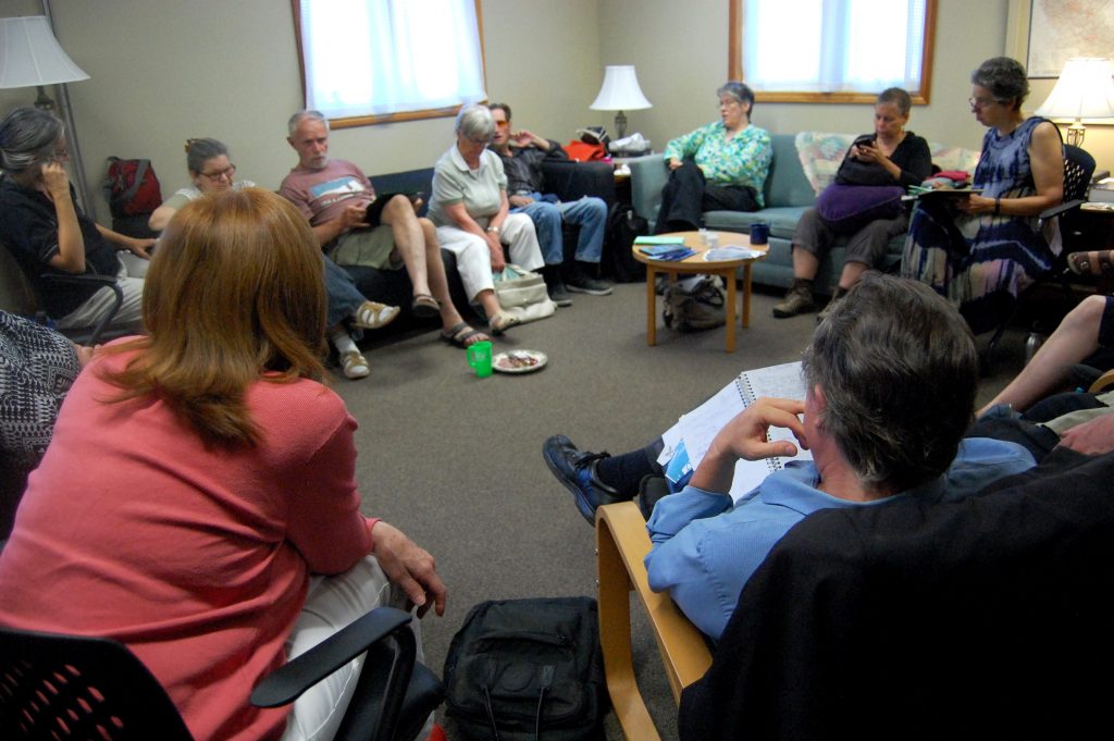 People sitting around the room at the KWPeace Potluck Meeting for Summer 2018