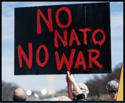 No NATO No War (person holding a black sign with red letters)